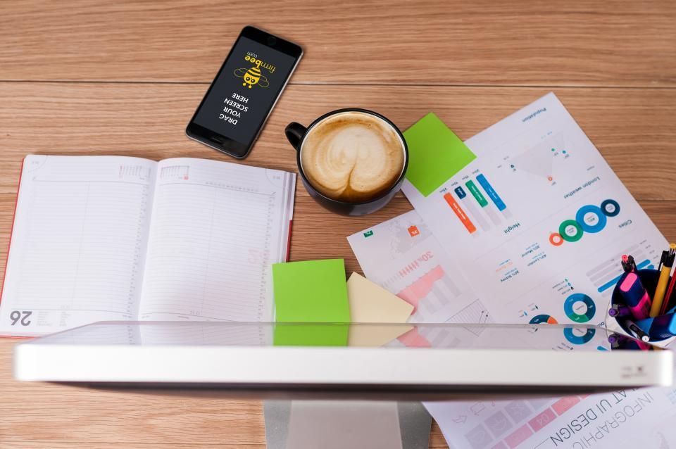 Printed charts and a laptop on an office desk